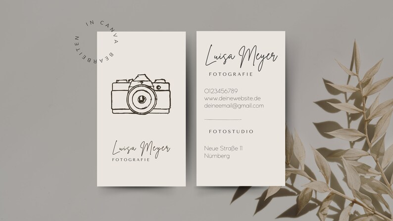 May include: A white business card with black text and a line drawing of a camera. The text reads "Luisa Meyer Fotografie" and includes contact information and the address of the photography studio.