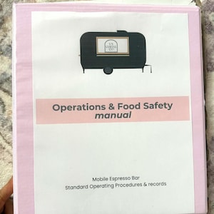 May include: A pink binder with the text "Operations & Food Safety manual" and "Mobile Espresso Bar Standard Operating Procedures & records." The cover features a black illustration of a mobile coffee shop.