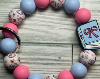 Pulsera con cuentas en forma de libro y clip para llavero