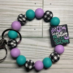 Pulsera con cuentas y clip para llavero con el logo de Villano