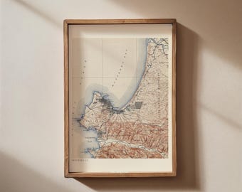 May include: A framed vintage map of the coastal area of Monderraga, Portugal. The map is printed in shades of brown, blue, and white, with detailed lines and markings indicating roads, rivers, and other geographical features.