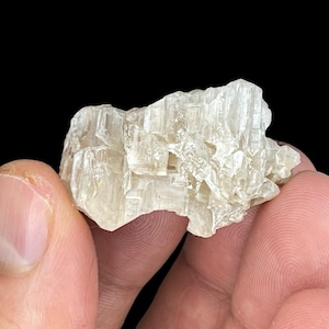 May include: A cluster of translucent, white, naturally formed crystals with a rough, textured surface.