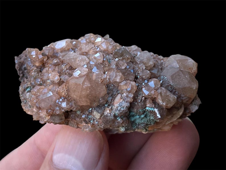 May include: A cluster of brown and clear quartz crystals on a matrix of dark brown and green rock. The crystals are translucent and have a glassy luster.