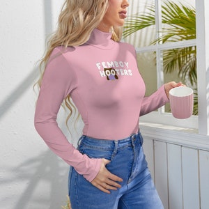 May include: A pink long-sleeved shirt with a mock neck and a graphic of an owl with the text "Femboy Hooters" on the front.