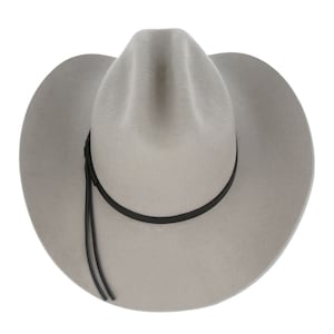 Pode incluir: Um chap&eacute;u de cowboy de feltro cinza com uma faixa de couro preta e uma correia de couro preta pendurada para baixo do lado.