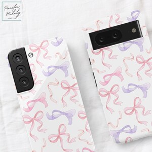 May include: Two phone cases with a white background and a pattern of pink and purple watercolor bows.