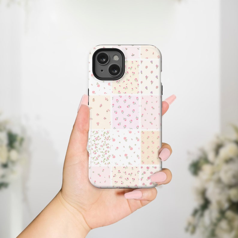 Op de afbeelding: Een witte iPhone-hoes met een patchwork-ontwerp met verschillende bloemenpatronen in roze, gele en cr&egrave;me tinten.
