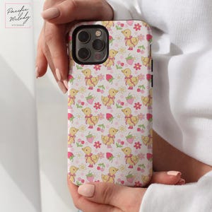 May include: A white phone case with a pattern of yellow ducklings, pink flowers, and red strawberries.