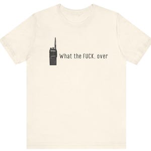 May include: A white t-shirt with a black walkie-talkie graphic and the text "What the FUCK. over" printed on the front.