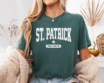 May include: A teal blue t-shirt with white text that reads "St. Patrick Pray for Us" and a white shamrock graphic.