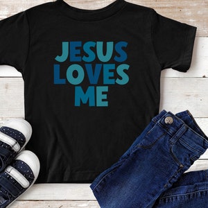 May include: Black t-shirt with the text "JESUS LOVES ME" in blue and teal letters.