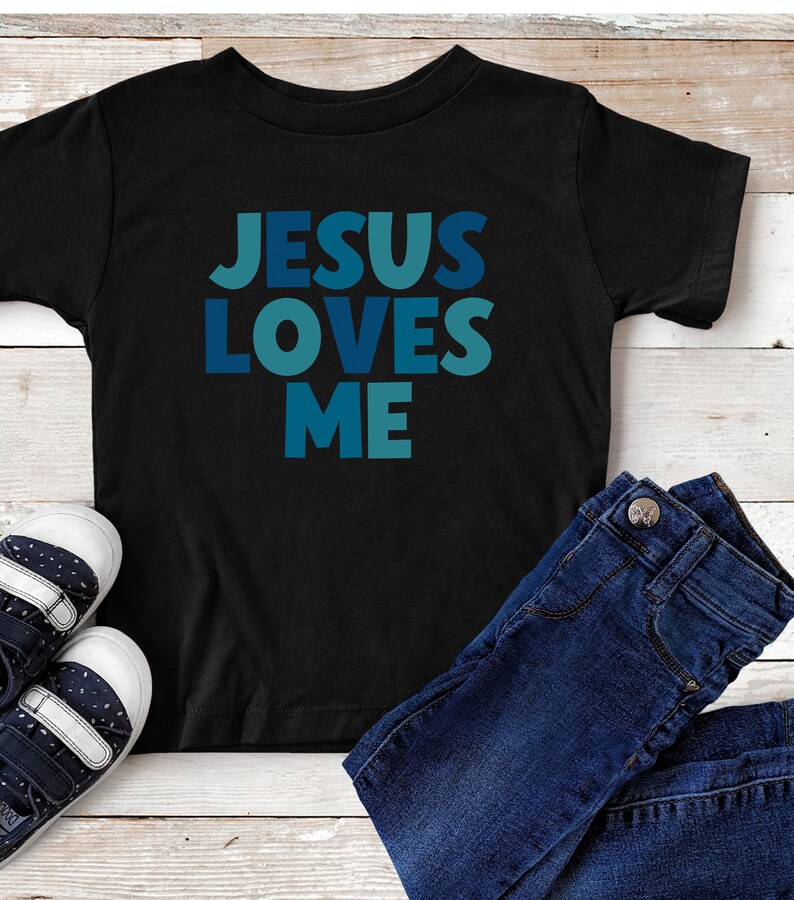 May include: Black t-shirt with the text "JESUS LOVES ME" in blue and teal letters.