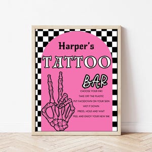 May include: A pink and black sign with the text "Harper's Tattoo Bar" and instructions for using temporary tattoos. The sign features a black and white chequered background and a skeleton hand making a peace sign.
