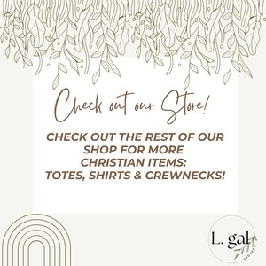 May include: A graphic with a floral design at the top and a white box with brown text that says "Check out our Store!" and "CHECK OUT THE REST OF OUR SHOP FOR MORE CHRISTIAN ITEMS: TOTES, SHIRTS & CREWNECKS!"  Below the box is a rainbow arch design and a brown circle with the text "L. gal" and "JUXI GAL" in a script font.