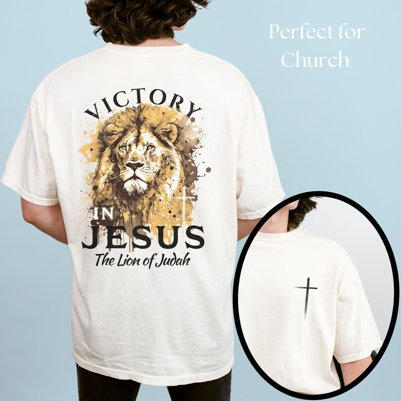 May include: A white t-shirt with a lion graphic and the text "Victory in Jesus The Lion of Judah". The back of the shirt has a small cross graphic.