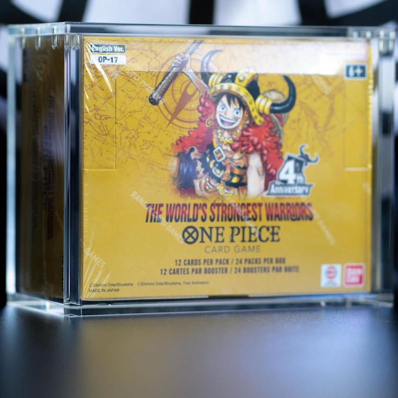 May include: A sealed One Piece Card Game booster box titled The World's Strongest Warriors OP-17, encased in a clear acrylic display case. The yellow box features an illustration of a character in a horned helmet and 4th Anniversary branding.