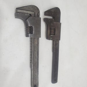 May include: Two adjustable wrenches, one silver and one black, with the text "BHM CORP BRIDGEPORT, CT, U.S.A." on the silver wrench. The silver wrench has a 9 in marking.