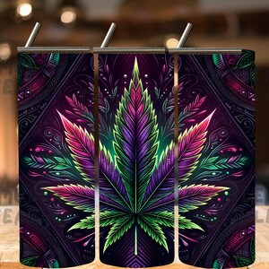 May include: Three stainless steel tumblers with a colorful psychedelic cannabis leaf design. The design features a dark purple, green, and pink leaf with intricate details.