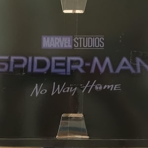 May include: A black and white image of the Marvel Studios logo with the text "Spider-Man No Way Home" in blue lettering.