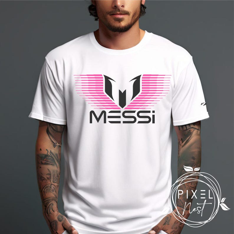 May include: White t-shirt with a pink and black graphic of a stylized "M" with the word "MESSI" underneath.