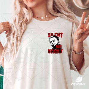 K&ouml;nnte beinhalten: Wei&szlig;es T-Shirt mit einer schwarzen und roten Grafik eines Horrorfilmcharakters. Die Grafik lautet "Silent But Deadly".