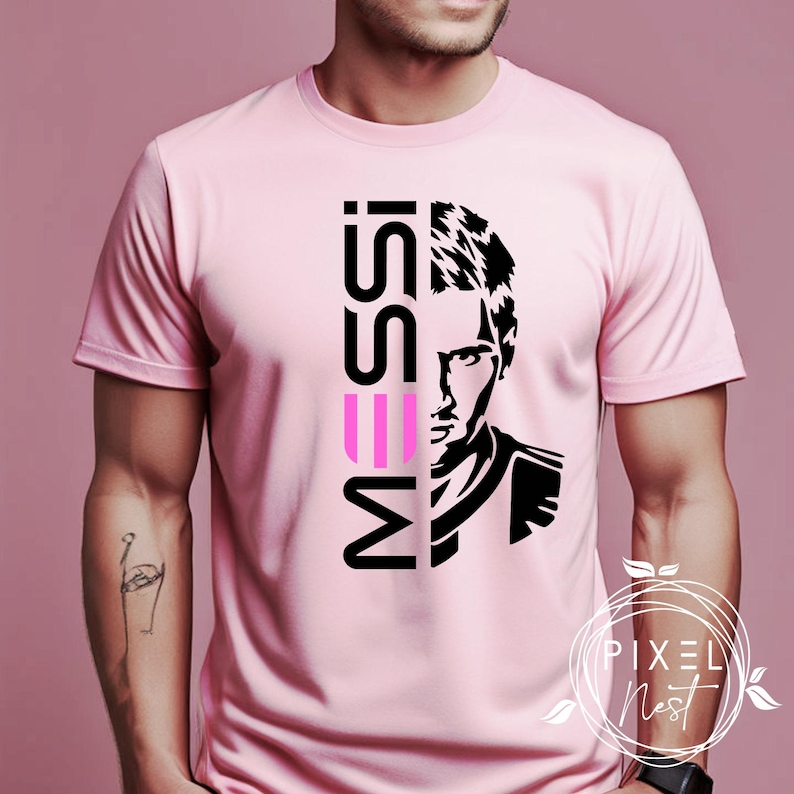 May include: Pink t-shirt with a black and white image of a soccer player and the word "MESSI" in pink and black letters.