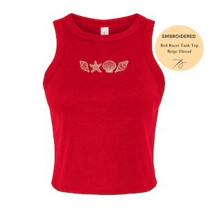 May include: A red racerback tank top with embroidered seashells and a starfish design in beige thread. The tank top has a round neckline and is sleeveless. The text "EMBROIDERED Red Racer Tank Top Beige Thread" is in the upper right corner.