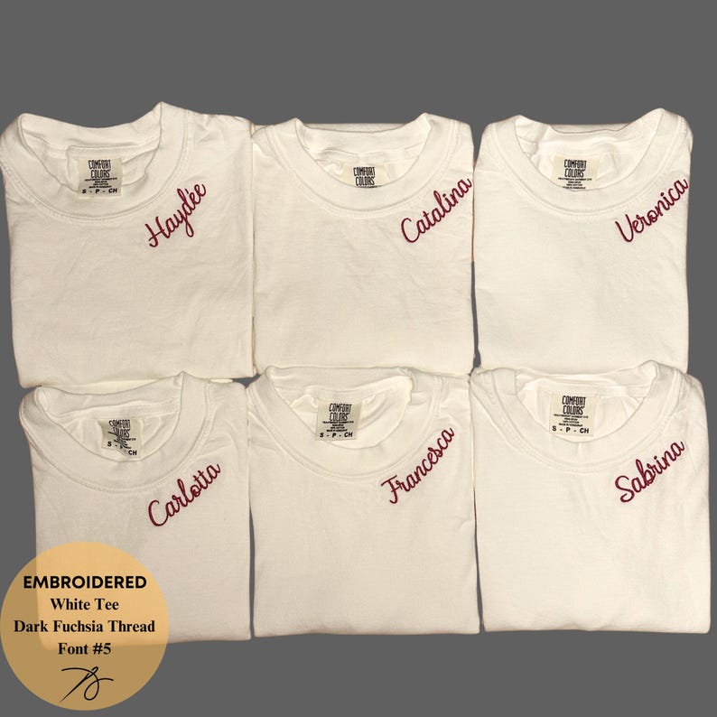May include: Six white t-shirts with embroidered names in dark fuchsia thread. The names are Haydee, Catalina, Veronica, Carlotta, Francesca, and Sabrina. The shirts are labeled with the text "COMFORT COLORS".