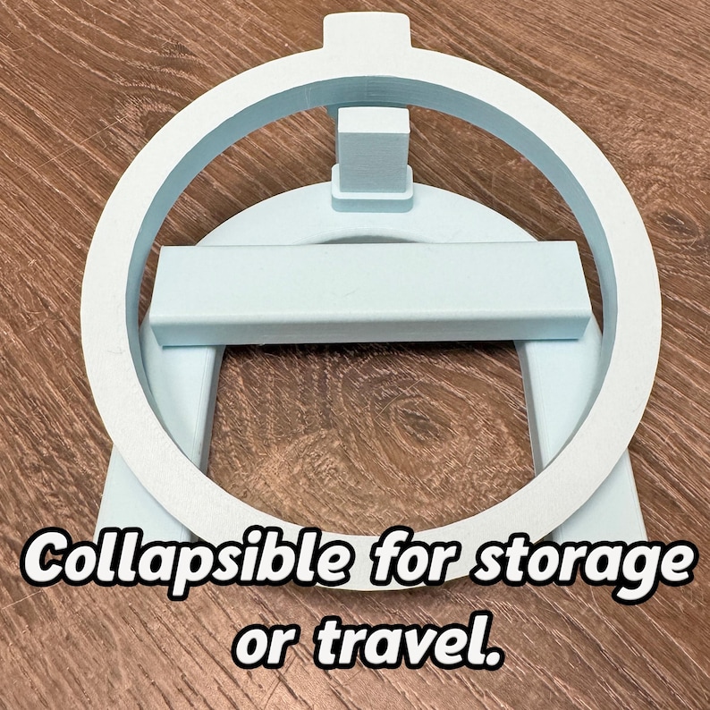 May include: A pale blue, collapsible stand with a circular top and rectangular base. The stand has a rectangular support and the text "Collapsible for storage or travel."