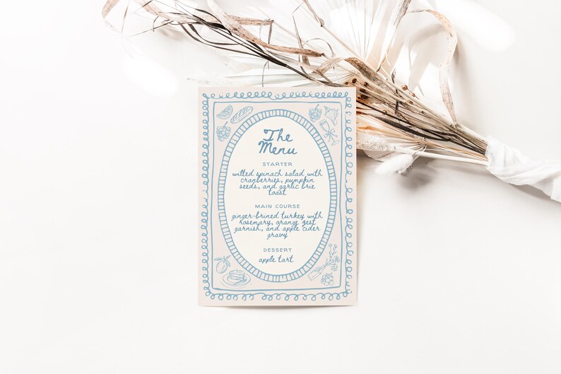 May include: A white card with a blue border and a blue oval in the center. The oval contains the text "The Menu" and lists the menu items: "Starter: Wilted spinach salad with cranberries, pumpkin seeds, and syrupy brie toast", "Main Course: Ginger brined turkey with rosemary, orange zest garnish, and apple cider gravy", "Dessert: Apple tart".