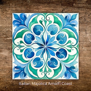 May include: Square ceramic tile with a symmetrical floral design in shades of blue and green on a white background. The tile is labeled "Italian Majolica Amalfi Coast".