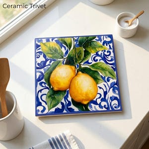May include: Square ceramic trivet with a vibrant lemon design. The trivet features two yellow lemons with green leaves against a blue and white patterned background. The text "Ceramic Trivet" is visible in the image.