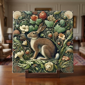 May include: A decorative square tile featuring a brown and white rabbit surrounded by flowers and foliage in shades of green, orange, and cream. The tile is displayed on a wooden stand, showcasing an artistic design suitable for home decor.