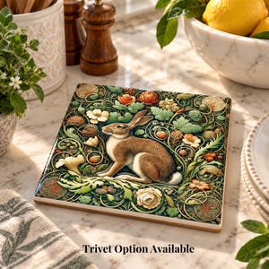 May include: A square ceramic coaster featuring a detailed illustration of a brown rabbit surrounded by intricate green vines, leaves, and colorful flowers in shades of orange, yellow, and white. The text Trivet Option Available is printed below.