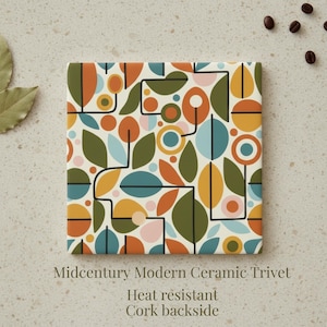 May include: A square ceramic trivet with a mid-century modern design. The trivet features a pattern of colorful leaves, circles, and lines in shades of orange, green, blue, and pink on a cream background. The text "Midcentury Modern Ceramic Trivet" is visible.