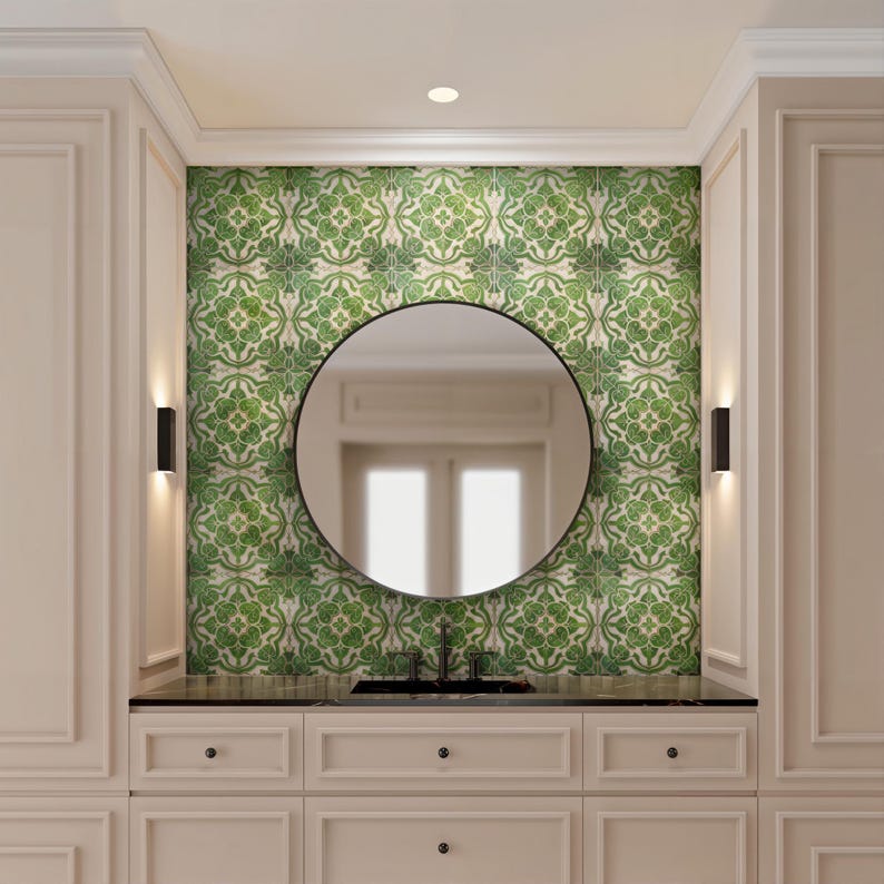 May include: A bathroom vanity with a black countertop, a round black mirror, and a green and white patterned tile backsplash. The vanity has cream-colored cabinets and two black sconces on either side of the mirror.