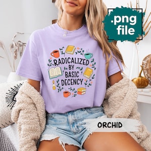 Op de afbeelding: Lichtpaarse t-shirt met de tekst "RADICALIZED BY BASIC DECENCY" in een cirkelvormig ontwerp met boeken, koffiekopjes en bloemaccenten. Het shirt is gemaakt van een zacht, comfortabel materiaal.