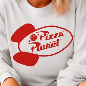 May include: White sweatshirt with a red rocket ship graphic and the text "Pizza Planet" on the front.
