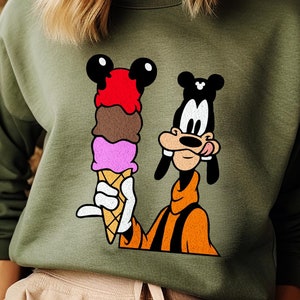 May include: Green sweatshirt with a cartoon image of Goofy holding a multi-colored ice cream cone.