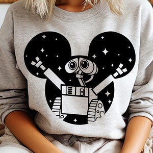 Puede incluir: Una sudadera gris con un gráfico en blanco y negro de un robot con una cabeza de Mickey Mouse. El robot tiene ojos grandes y está rodeado de estrellas.