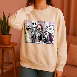 Puede incluir: Sudadera beige con un gráfico de personajes de Pesadilla antes de Navidad. El diseño incluye imágenes de Oogie Boogie, Jack Skellington, Sally, Zero y el Alcalde. La sudadera es de color neutro y tiene cuello redondo.