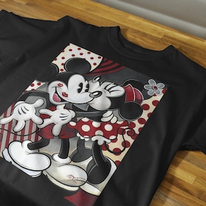 May include: Black t-shirt with a graphic print of Mickey Mouse and Minnie Mouse kissing. The graphic is in a red, white, and black color scheme with polka dots and stripes.