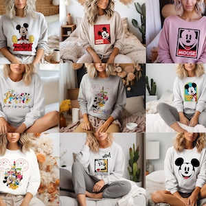 May include: A collection of nine different Mickey Mouse themed sweatshirts. The sweatshirts are all white, grey, or pink and feature various Mickey Mouse designs, including a classic Mickey Mouse head, a Mickey Mouse with the words "Mickey Mouse" underneath, and a Mickey Mouse with the words "Friends" underneath.