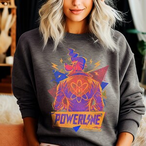 May include: A gray sweatshirt with a colorful graphic print of a cartoon character with a lightning bolt and the word "POWERLINE" in yellow letters.
