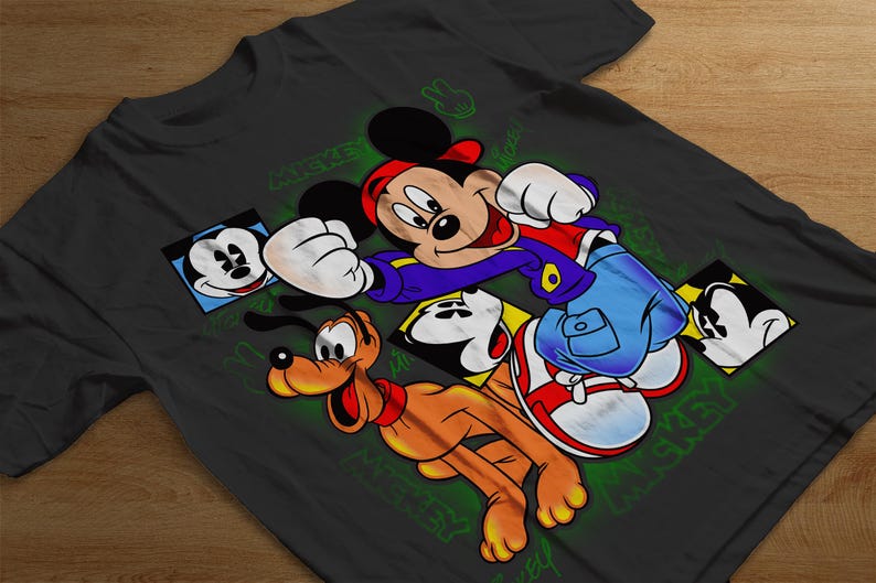 May include: A black t-shirt with a colorful graphic print of Mickey Mouse, Pluto, and other Disney characters. The graphic features the characters in a cartoon style with bright colors and bold outlines. The text "Mickey Mouse" is printed on the shirt in a green font.