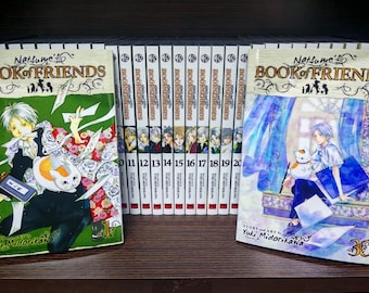 Puede incluir: Una colección de volúmenes de manga "Natsume's Book of Friends". La imagen muestra los volúmenes 1 y 30 en primer plano, con los volúmenes 11-20 alineados en el fondo. Las portadas presentan ilustraciones coloridas de personajes.