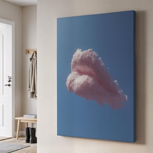 May include: A canvas art print featuring a fluffy, pink cloud against a clear, light blue sky. The cloud has a soft, textured appearance. The artwork is displayed on a wall in a room with a door and a bench.