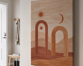 Puede incluir: Impresión artística rectangular en lienzo que representa un paisaje desértico con un sol, una luna y diseños de arcos en tonos marrones, naranjas y beige. La obra de arte está montada en una pared en un pasillo de tonos neutros.