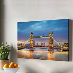 Könnte beinhalten: Eine Nachtaufnahme der Tower Bridge in London, England. Die Brücke ist mit goldenem Licht beleuchtet, und die Themse ist ruhig und reflektierend. Die Skyline der Stadt ist im Hintergrund zu sehen.