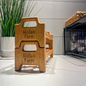 Peut inclure: Un &eacute;tag&egrave;re en bois &agrave; deux niveaux avec les mots "Hollen Farm" grav&eacute;s sur chaque niveau. L'&eacute;tag&egrave;re est en bois brun clair et a un aspect rustique.